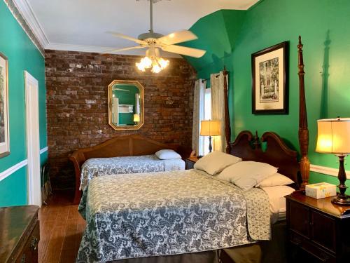 a bedroom with two beds and a ceiling fan at Hotel Villa Convento in New Orleans