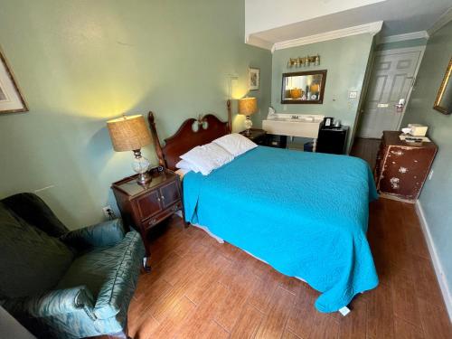 a bedroom with a bed and a couch and a sink at Hotel Villa Convento in New Orleans