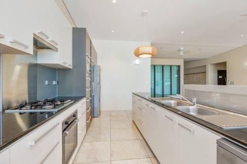a large kitchen with stainless steel appliances and counters at Bayview Paradise with Private Pool-Marina Deck in Stuart Park