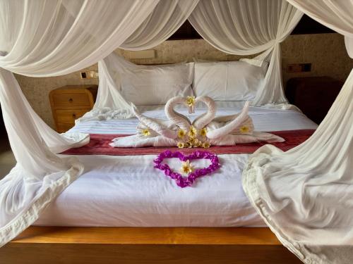 a bed with two swans made out of hearts at Jungle Paradise in Nusa Penida