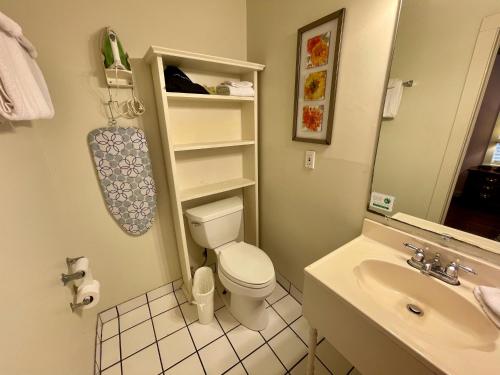 a bathroom with a white toilet and a sink at Hotel Villa Convento in New Orleans