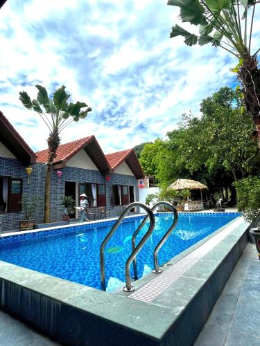 a swimming pool with two metal rails next to a house at Tam Coc Westlake Homestay in Ninh Binh