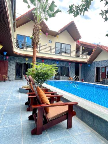 a row of lounge chairs next to a swimming pool at Tam Coc Westlake Homestay in Ninh Binh