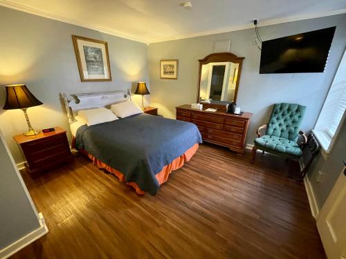 a bedroom with a bed and a chair and a mirror at Hotel Villa Convento in New Orleans