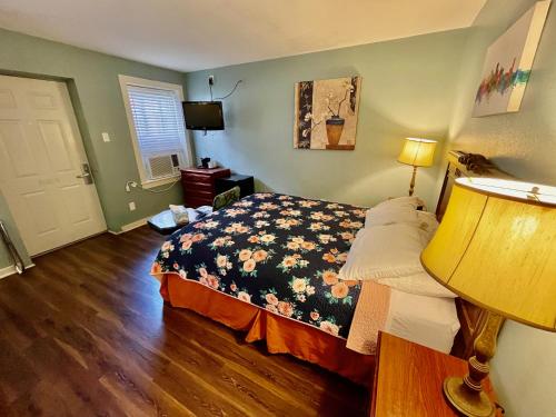 a bedroom with a bed and a lamp and a door at Hotel Villa Convento in New Orleans