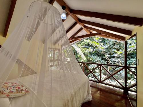a bedroom with a bed with a mosquito net at Villa Colibri - Secluded Jungle Villa - Short Stroll to Beach, Shops & Restaurants in Cocles