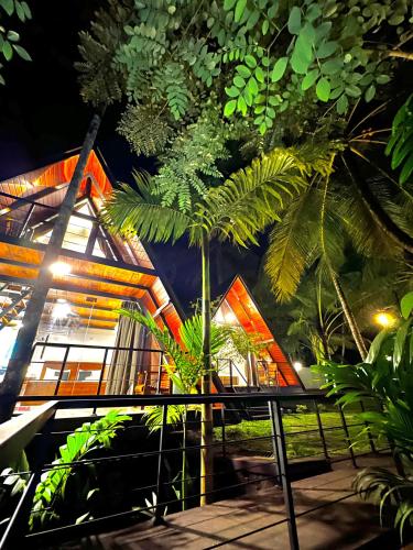 a building with a palm tree in front of it at Rustic Cottages Udawalawe in Udawalawe