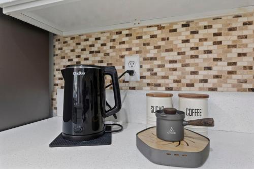 a black coffee maker and two cups on a counter at ZEN - A home away from home and in HEART of Las Vegas in Las Vegas