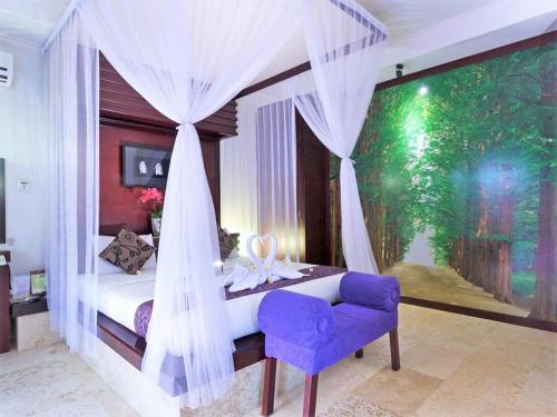 a bedroom with a canopy bed with a purple chair at Romantic Private Villas Kuta Bali in Kuta