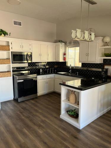 a kitchen with white cabinets and black appliances at Peaceful Vegas in Las Vegas