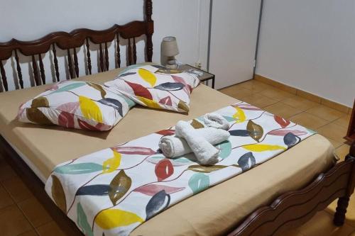a pair of beds with colorful blankets and pillows at L'ambre in Deshauteurs
