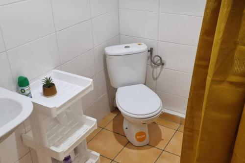 a bathroom with a white toilet and a sink at L'ambre in Deshauteurs
