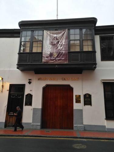 a man walking past a building with a sign on it at Apartamento en Centro Historico de Lima in Lima