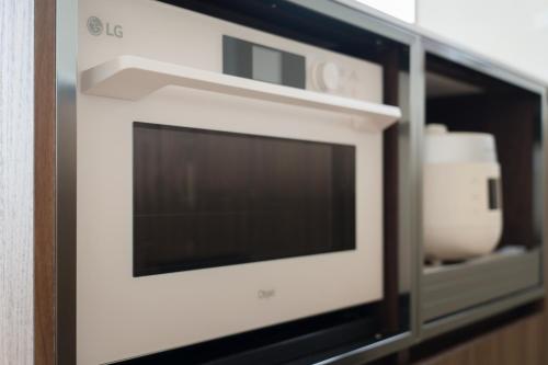 a microwave oven in a kitchen with a glass door at Soye stay in Gyeongju