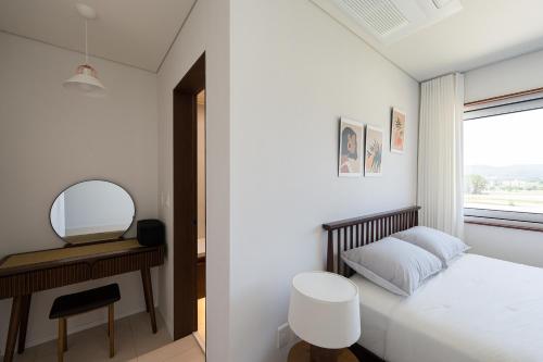 a small bedroom with a bed and a mirror at Soye stay in Gyeongju