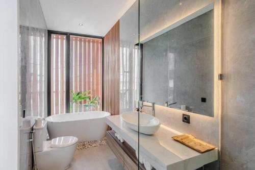 克罗柏坎Casa Estella Stunning 2BR in Umalas Canggu的带白色浴缸和水槽的浴室