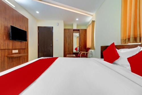 a bedroom with a large white bed with red pillows at Hotel O Silver House Near Mantri Square Mall in Bengaluru