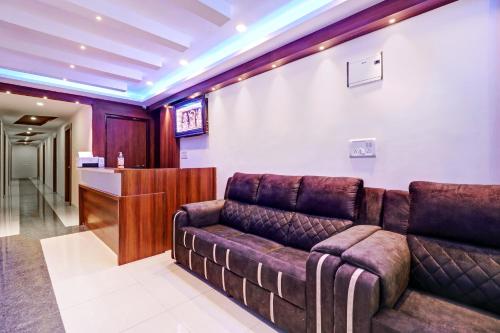 a living room with a couch and a bar at Hotel O Silver House Near Mantri Square Mall in Bengaluru