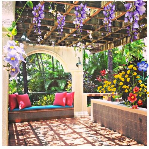 an outdoor seating area with purple and purple flowers at Villa Celeste Bed & Breakfast in El Río Arriba