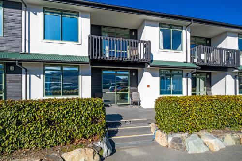 an apartment building with bushes in front of it at Lake Tekapo Village Motel in Lake Tekapo
