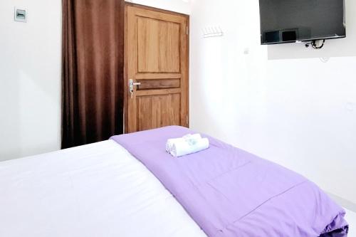 a bedroom with a bed with a towel on it at Sendang Syariah RedPartner in Kediri