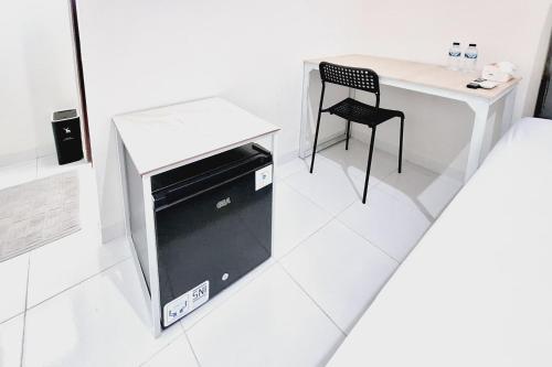a white room with a table and a chair at Sendang Syariah RedPartner in Kediri