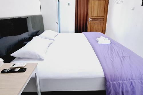a bedroom with a bed and a desk with a remote control at Sendang Syariah RedPartner in Kediri