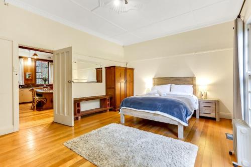 a bedroom with a large bed and a bathroom at Magnolia Gardens - 2 Perrins Creek Rd Olinda in Olinda