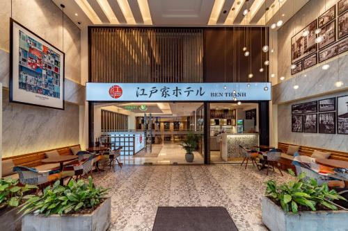 a restaurant with tables and chairs in a building at Edoya Hotel Ben Thanh in Ho Chi Minh City