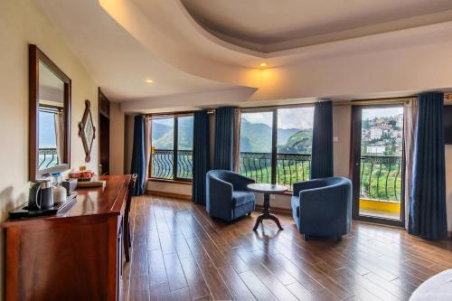 a hotel room with a desk and chairs and windows at Sapa Charm Hotel in Sapa