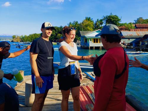 a group of people standing on a dock near the water at Sunari Beach Resort Selayar - Real in Pareangang