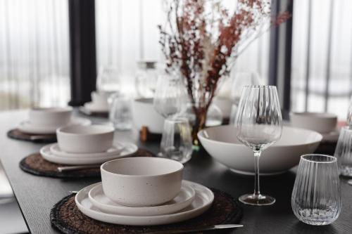 a table with plates and cups and wine glasses at Lachlan Retreat,Trevallyn in Launceston