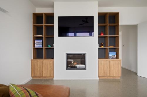 a living room with a fireplace and a flat screen tv at Lachlan Retreat,Trevallyn in Launceston