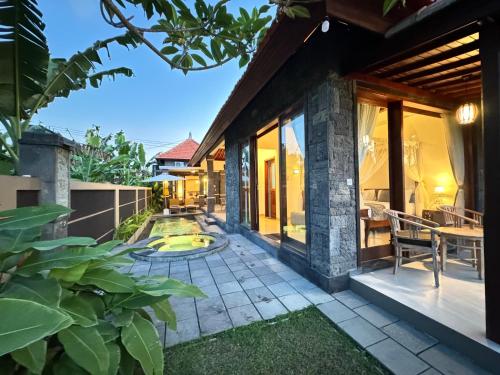a patio of a house with a swimming pool at Alam Petanu in Ubud