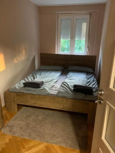 a bed in a room with a window at Relax apartman in Siófok