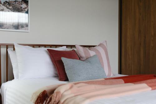 a bed with a bunch of pillows on it at Lachlan Retreat,Trevallyn in Launceston