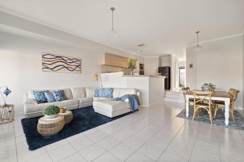 マンジュラにあるCanal Villa & Jetty-dolphin Views Walk-beachtownのソファとテーブルのあるリビングルーム