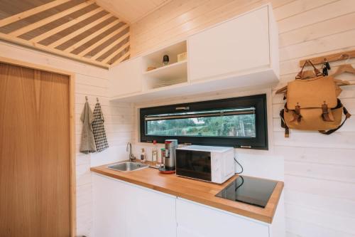 - une cuisine dans une petite maison avec un four micro-ondes dans l'établissement La Voie Romaine by Tiny Away, à Saint-Sébastien