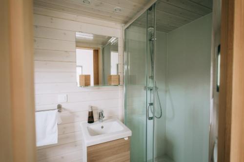 a bathroom with a glass shower and a sink at La Voie Romaine by Tiny Away in Saint-Sébastien