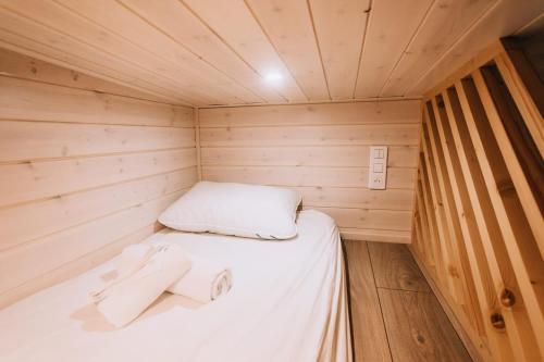 a small room with a bed in a wooden cabin at La Voie Romaine by Tiny Away in Saint-Sébastien