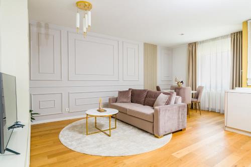 a living room with a couch and a table at Mido Aviatie Park Apartments with Private Parking & Self Check-in in Bucharest