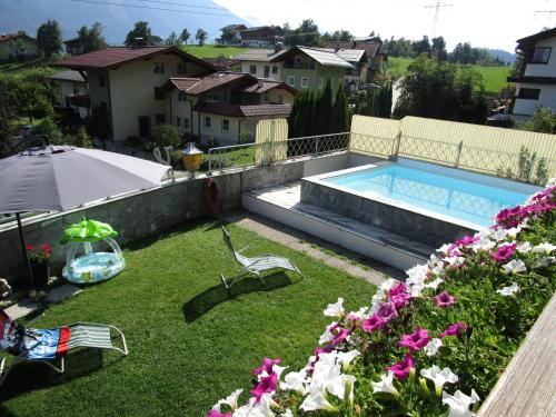 a backyard with a swimming pool and some flowers at Haus Sonnenterrasse in Sankt Veit im Pongau