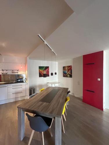 une salle à manger avec une table et des chaises en bois dans l'établissement L'Empereur 6p climatisation, à Montauban