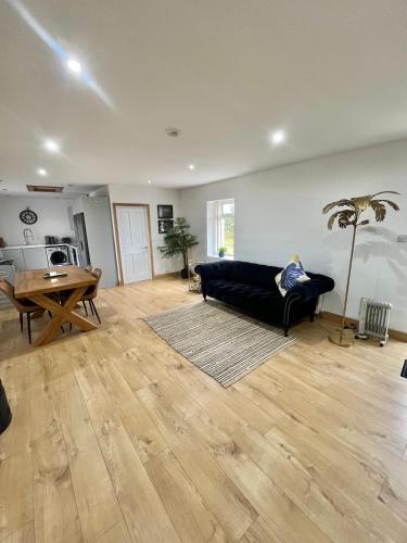 a living room with a black couch and a table at Unique countryside stay in Dundrod