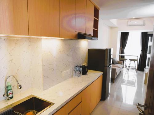 a kitchen with a counter top and a refrigerator at Meisterstadt Pollux Habibie in Batam Center