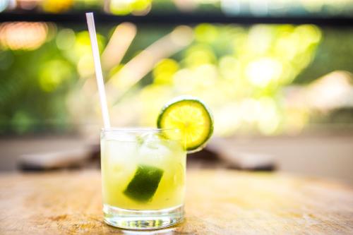 a drink sitting on a table with a slice of lime at Hotel Metrópole in São Lourenço