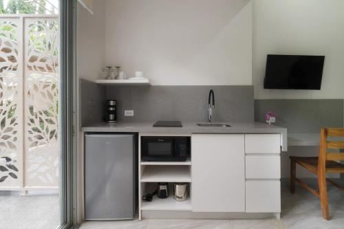 a kitchen with a counter with a sink and a microwave at Tamarindo Bay Boutique Hotel, Apartments & Suites in Tamarindo