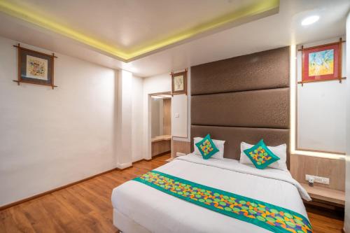 a bedroom with a large bed with a large headboard at Treebo Kamal Regency in Bhopal