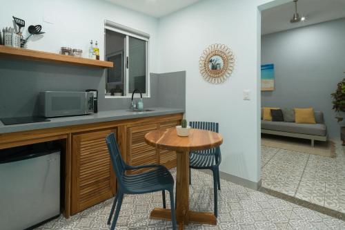 a kitchen with a small table and two chairs at Tamarindo Bay Boutique Hotel, Apartments & Suites in Tamarindo