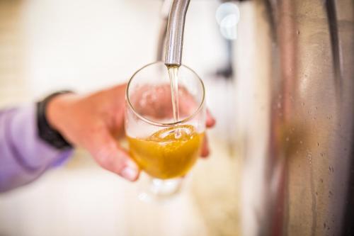 a person is holding a glass of orange juice at Hotel Metrópole in São Lourenço